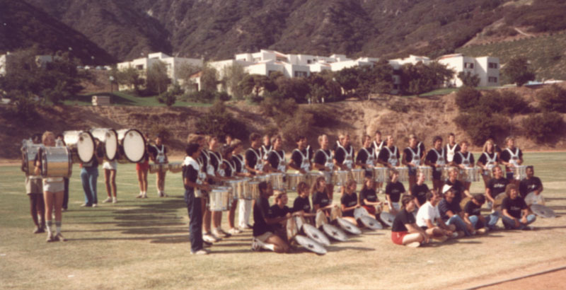 Olympic Band Drumline, Jennifer Judkins seated at front in black shirt and red shorts