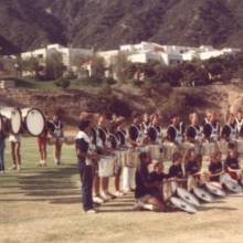 Olympic Band Drumline, Jennifer Judkins seated at front in black shirt and red shorts
