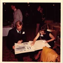 Clarence Sawhill Retirement Banquet looking at yearbooks