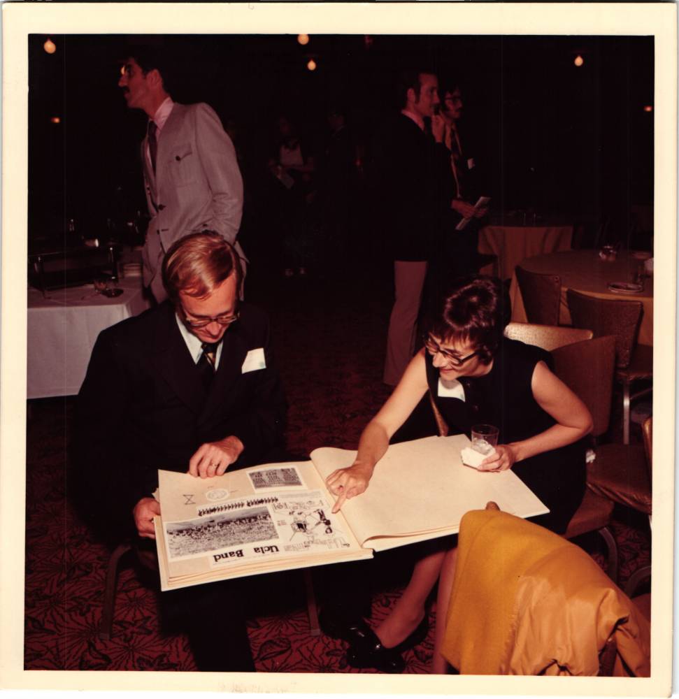 Clarence Sawhill Retirement Banquet looking at yearbooks